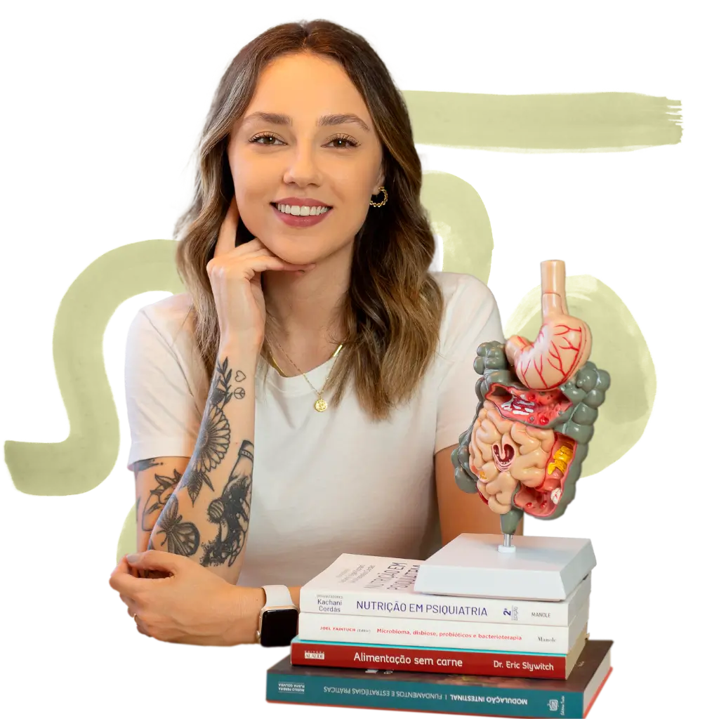 nutricionista barbara santana debruçada em livros apontando para um modelo de intestino