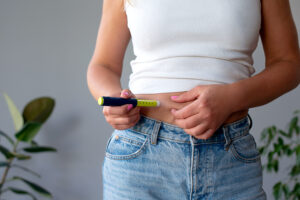 woman suffering from sugar diabetes giving insulin injection at home using diabetic pen Nutricionista Bárbara SantAna